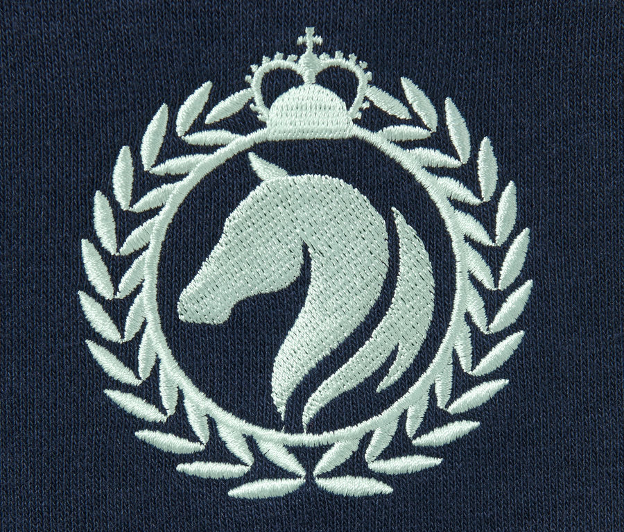 Detail modrej mikiny s vyšitým bielym logom koňa v kruhu s korunou.
