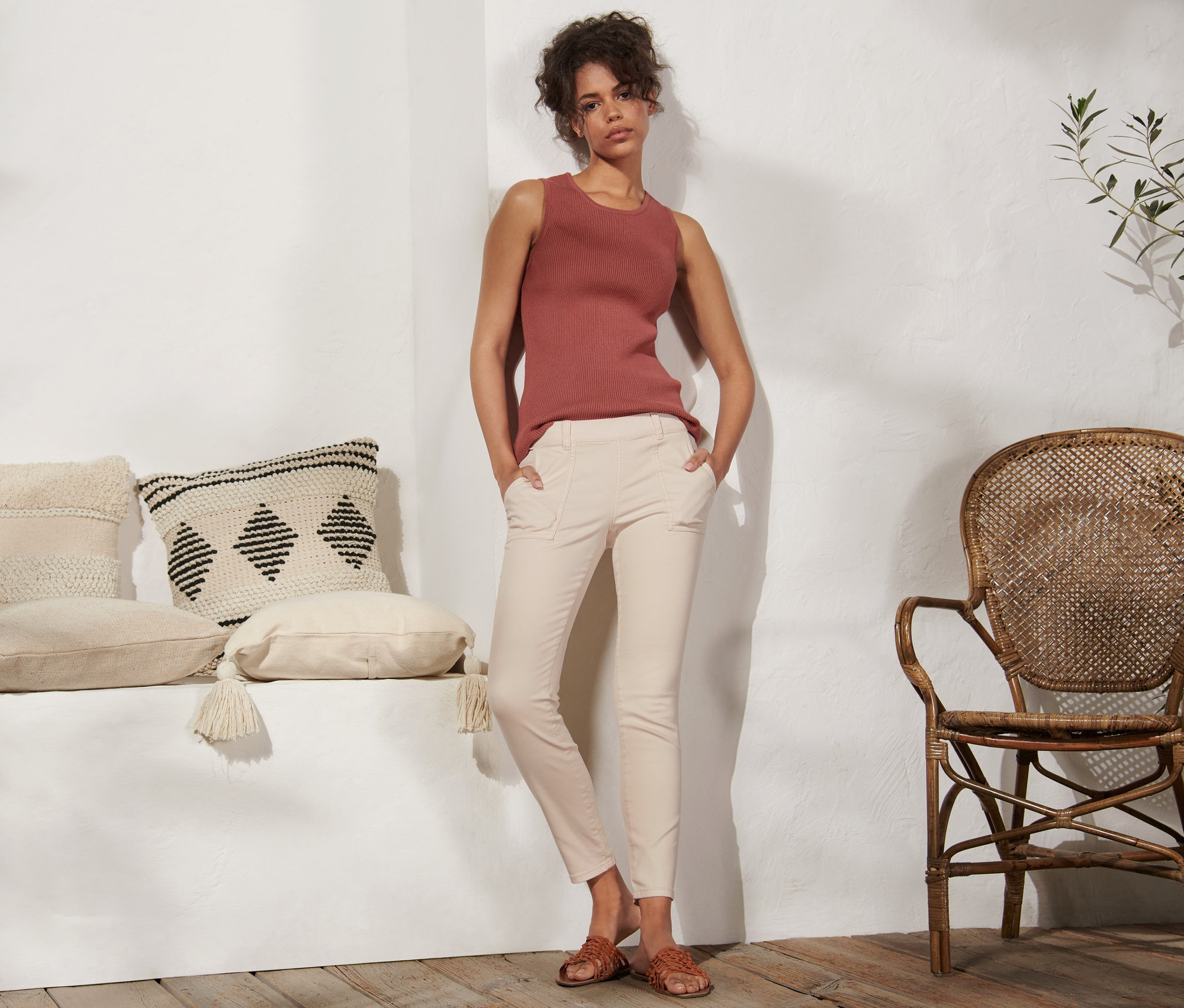 Žena stojí a má ruky vo vreckách krémových tregín.