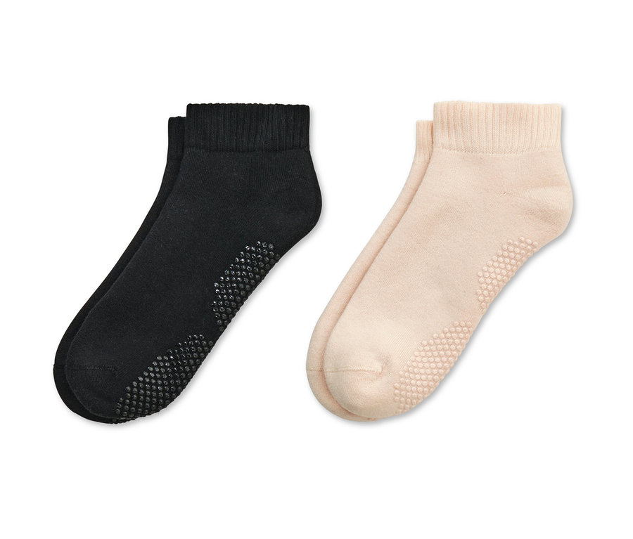 Dva páry ponožiek na jogu, jedny čierne a jedny béžové.