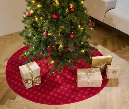 Vianočný stromček s červenou dekou pod stromček a darčekmi.