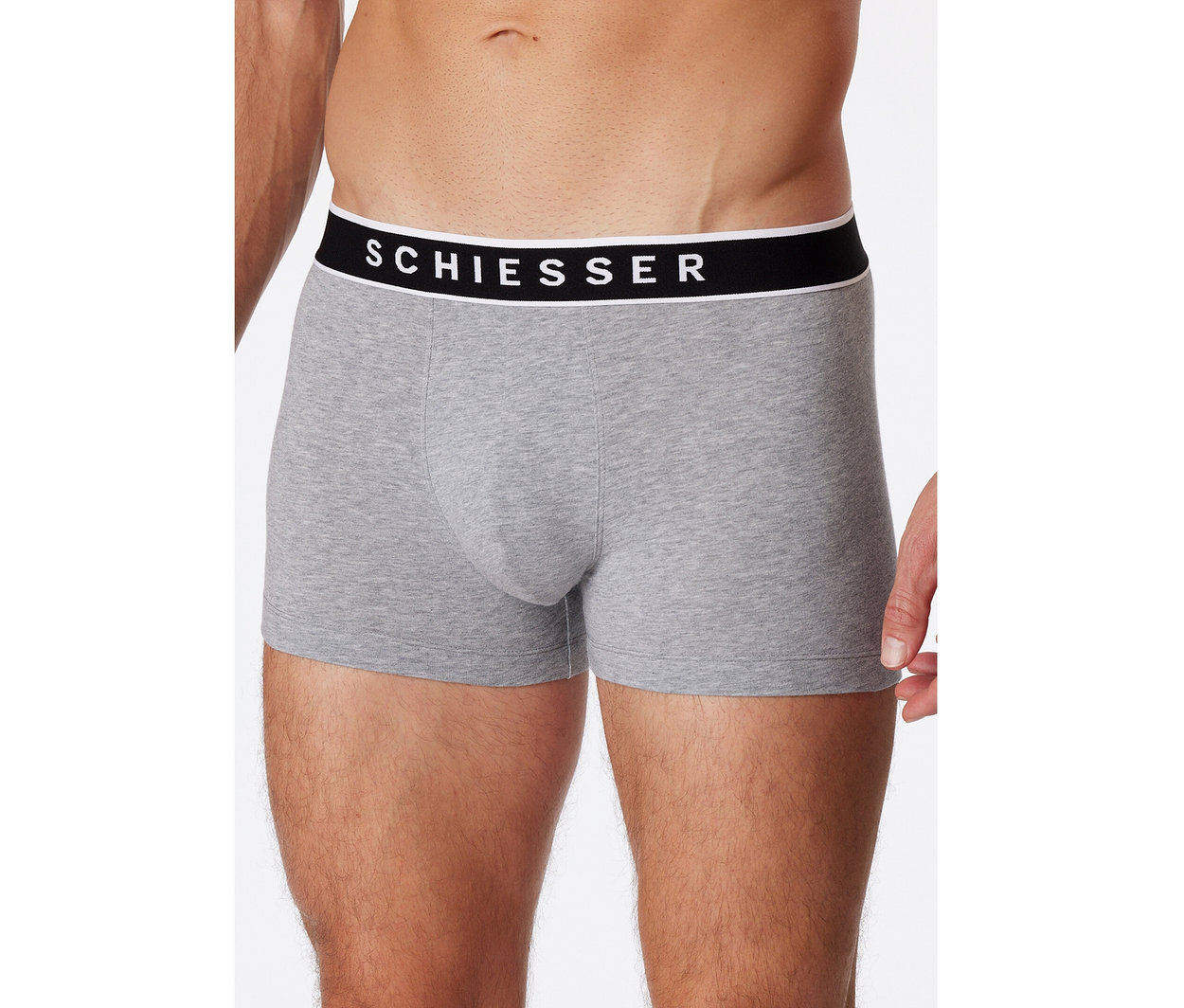 Muž má na sebe sivé melírované boxerky SCHIESSER s čiernym pásom a bielym logom.