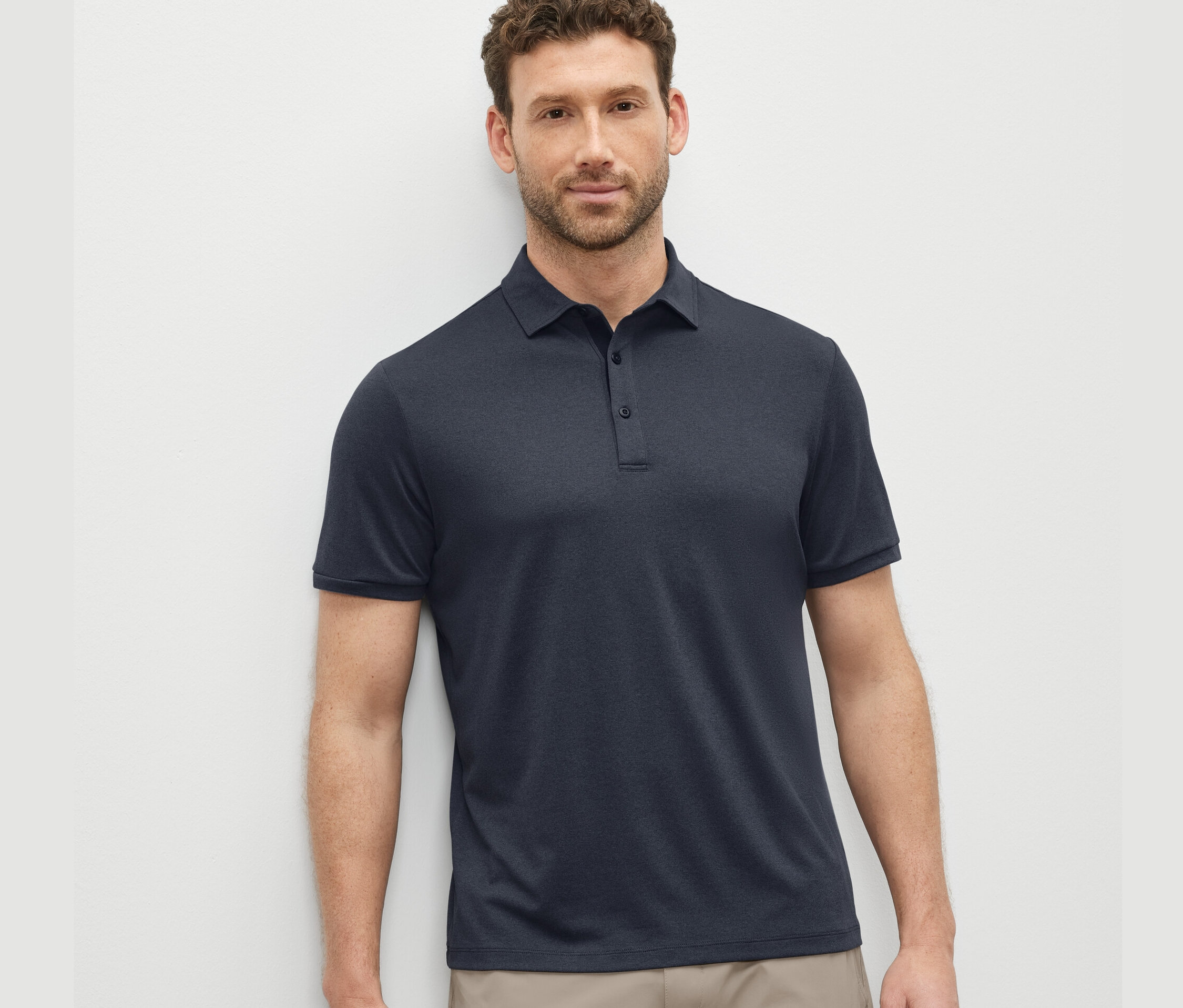 Muž má na sebe modré funkčné polo tričko.