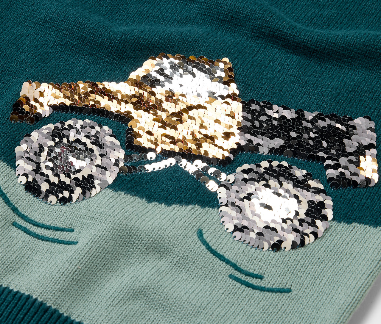 Detailný pohľad na detský pletený sveter s motívom trblietavého nákladného auta.