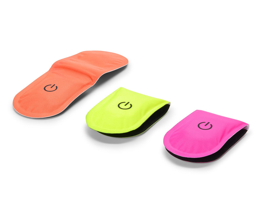 Oranžová vložka do topánky leží vedľa žltého a ružového blikajúceho svetla.