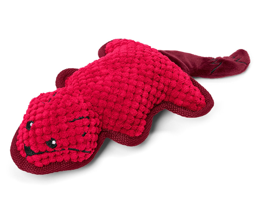 Červená plyšová hračka v tvare zvieraťa leží na bielom pozadí.