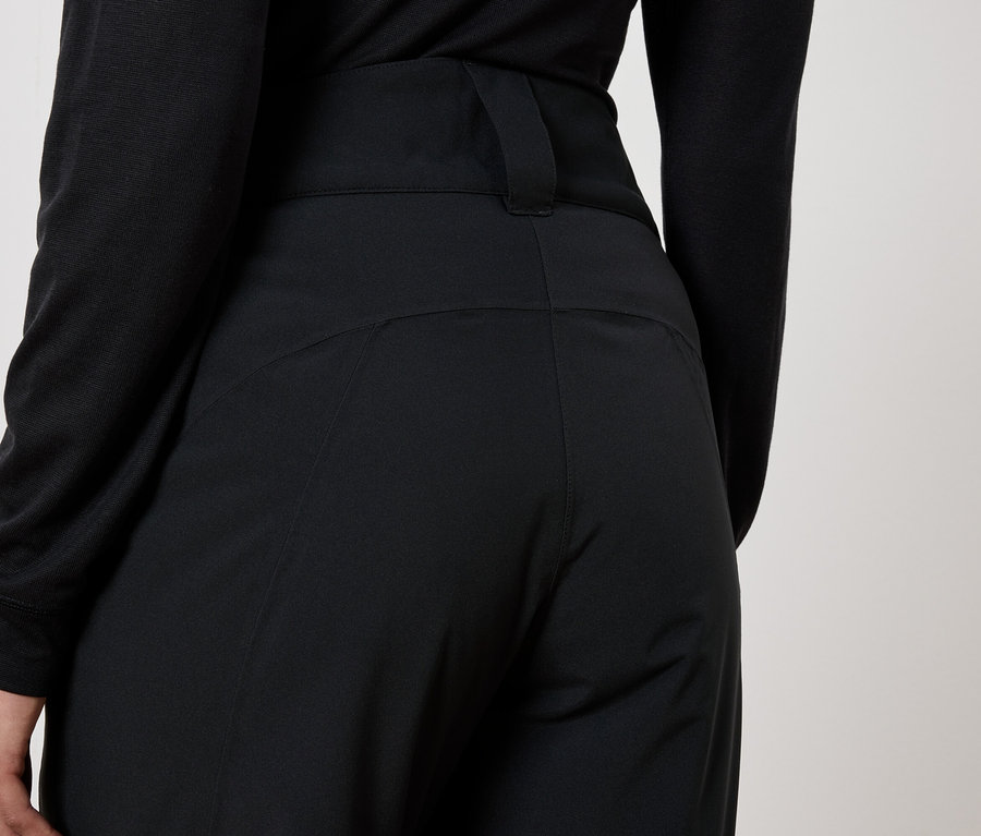 Pohľad zozadu na ženu v čiernych nohaviciach a čiernom tope.