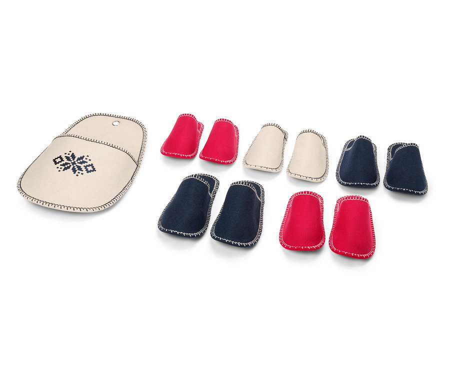 Puzdro na ihlice s výšivkou vedľa sady červených, krémových a modrých chráničov na ihlice.