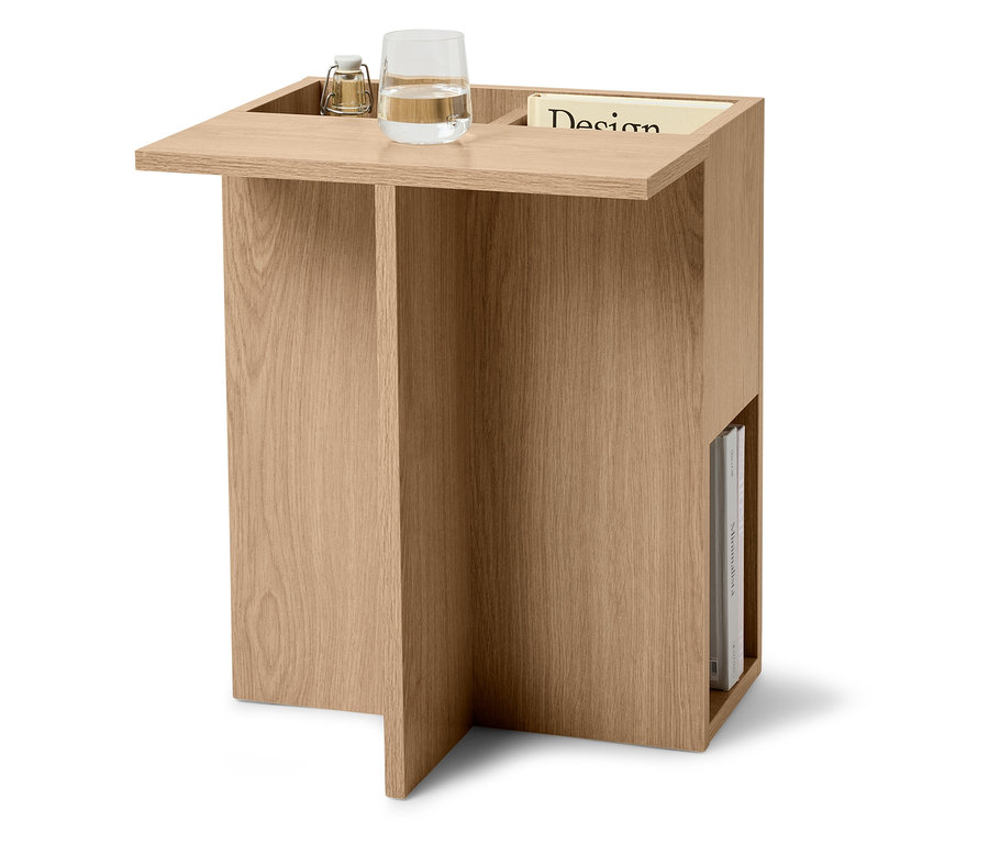 Príručný stolík zo svetlého dreva s pohárom vody, lampou a časopisom.