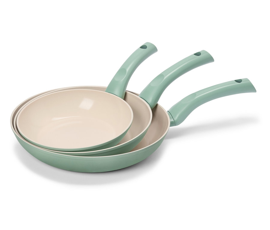 Tri zelené panvice s krémovými vnútornými povrchmi sú naskladané na sebe.