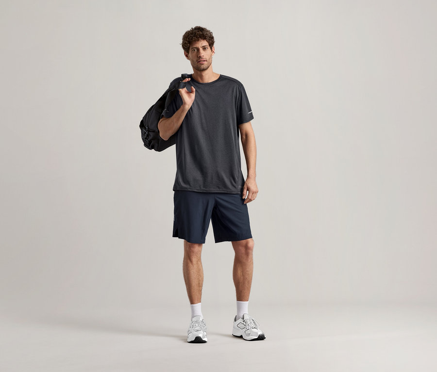 Muž v antracitovom športovom tričku a so športovou taškou prehodenou cez rameno.