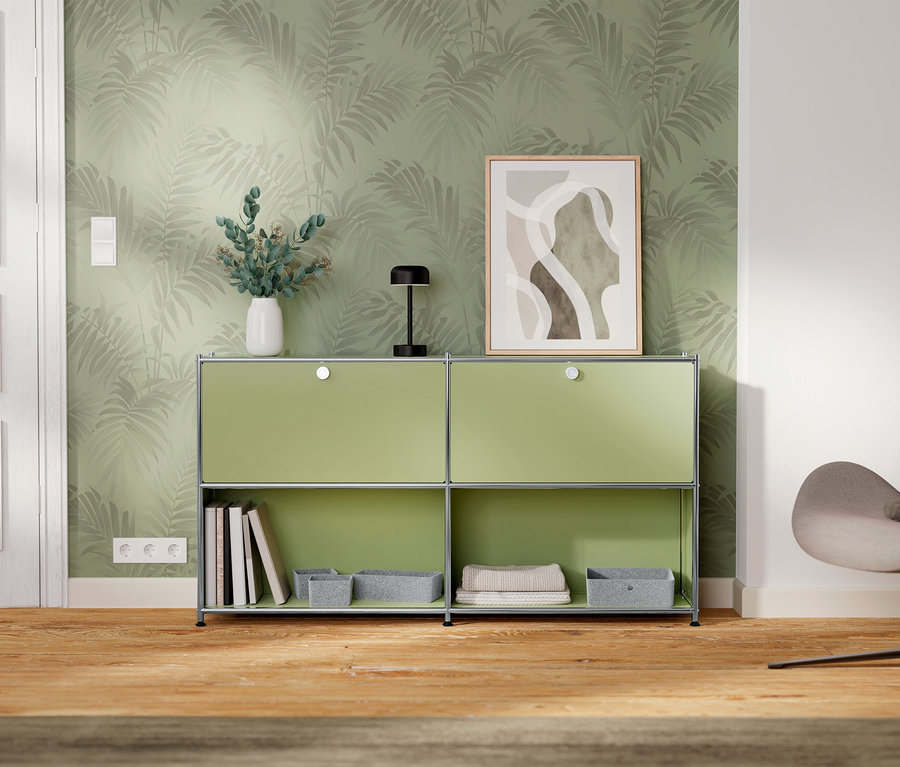 Zelená skrinka s dvomi priehradkami stojí pri stene s tapetou so vzorom listov.