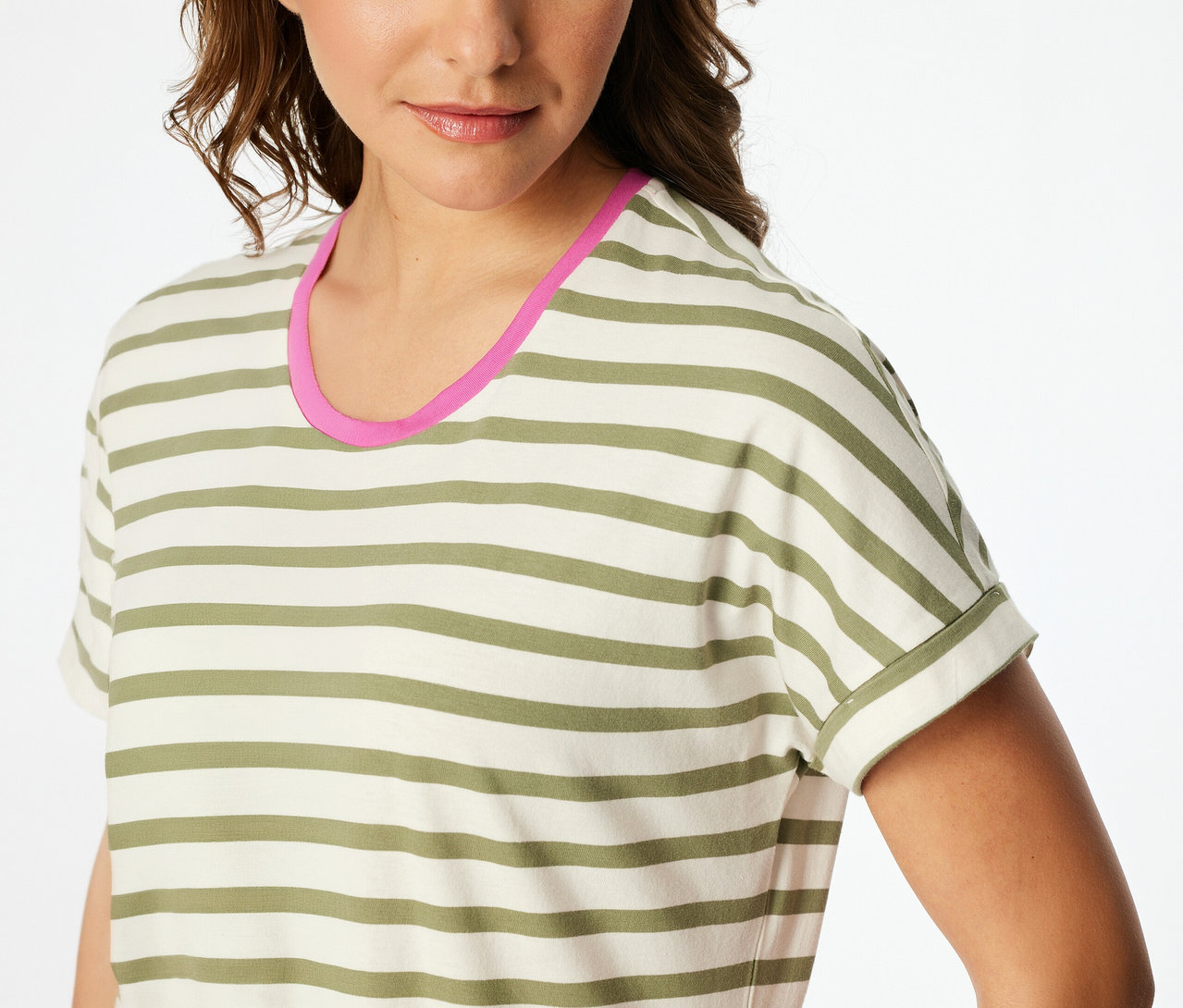 Žena má na sebe pruhovanú nočnú košeľu SCHIESSER v krémovej a olivovozelenej farbe s ružovým lemovaním výstrihu.