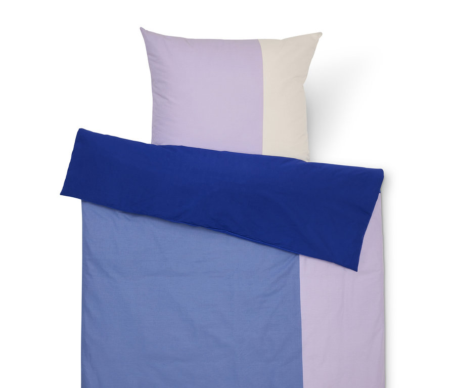 Súprava posteľnej bielizne s modrým obliečkom, fialovou a krémovou obliečkou na vankúš.