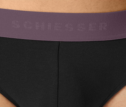 Detail pánskych čiernych slipov s fialovým pásom značky Schiesser.