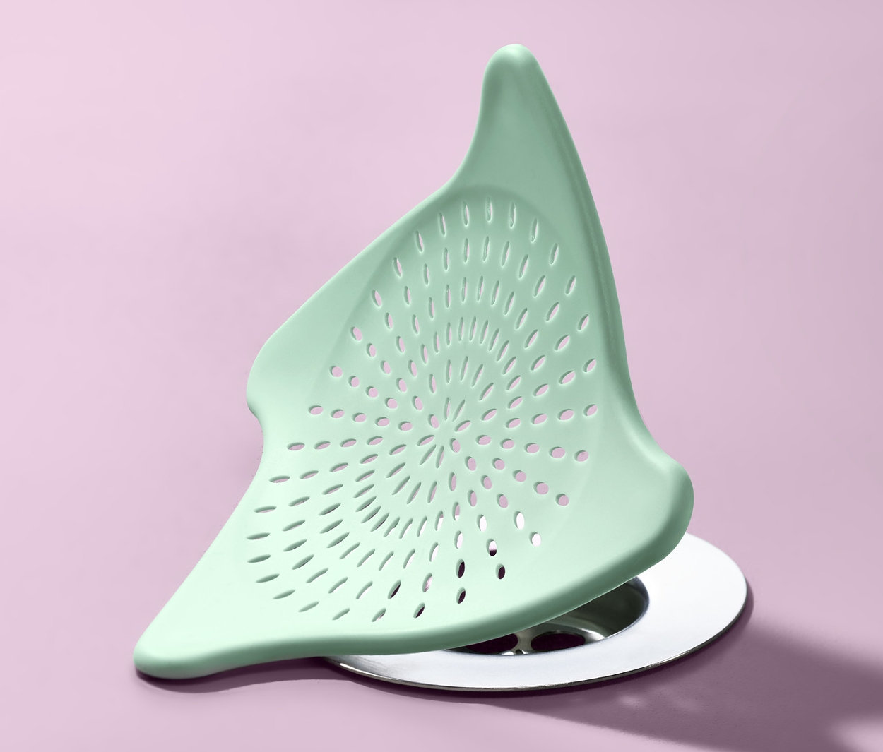 Zelené silikónové odtokové sitko na fialovom pozadí.