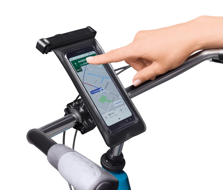 Prst sa dotýka smartfónu v držiaku na smartfón na bicykel.