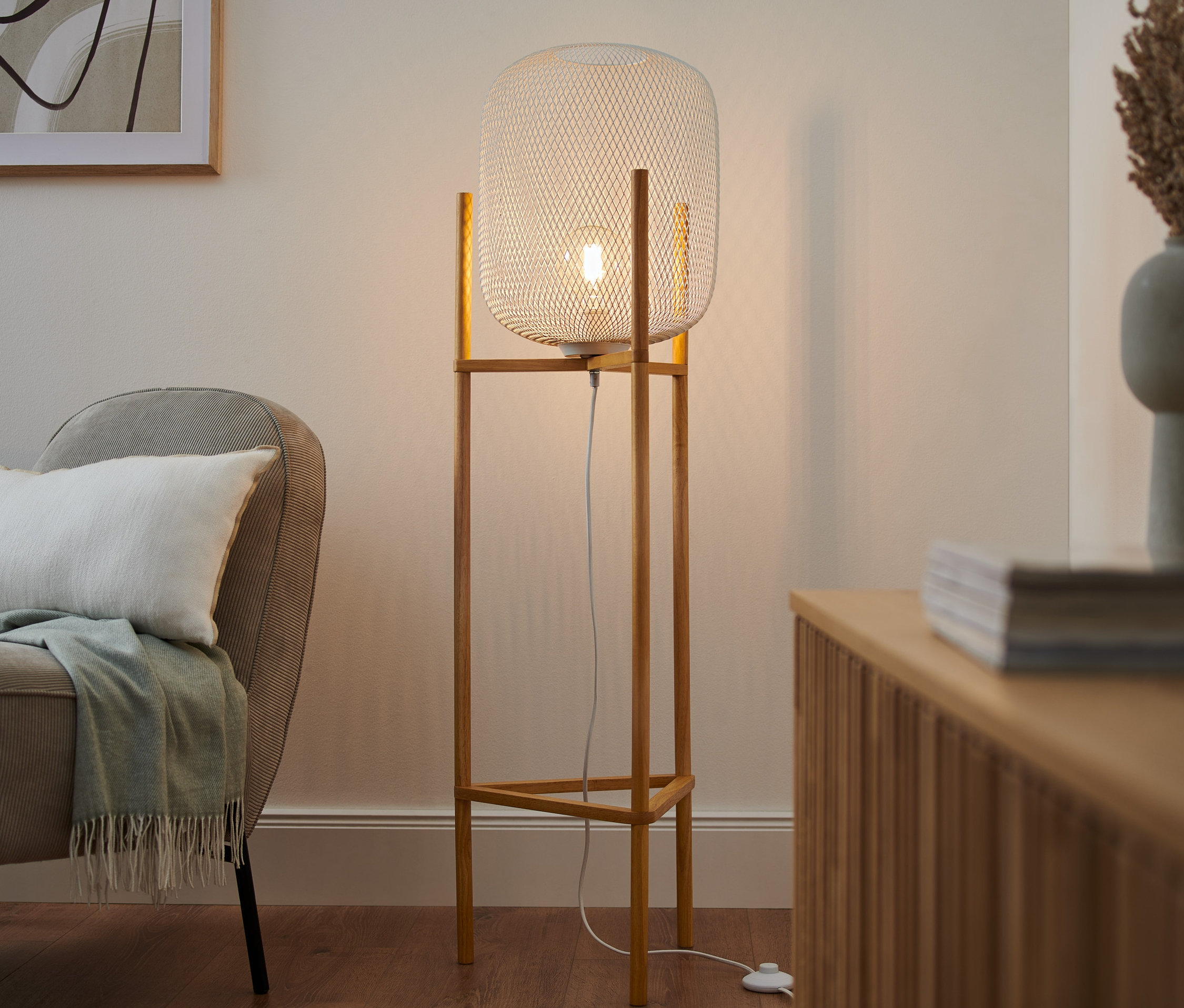 V obývacej izbe stojí trojnohá stojacia lampa.