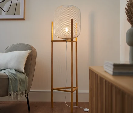 V obývacej izbe stojí trojnohá stojacia lampa.