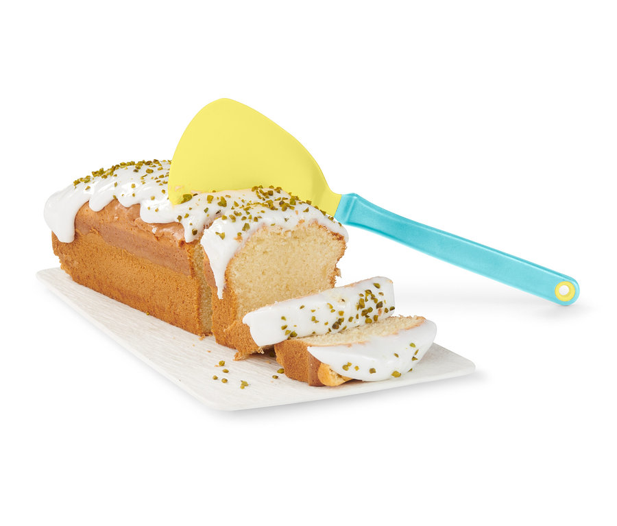 Bábovka s polevou a posýpkou na tanieri, žltá obracačka na palacinky a lievance.