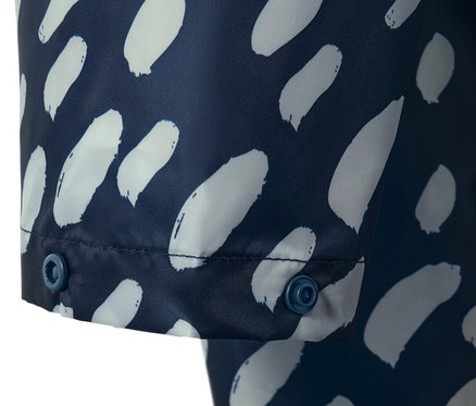 Detail modrého ponča do dažďa s bielym vzorom a rukávmi, zapínané na patentky.