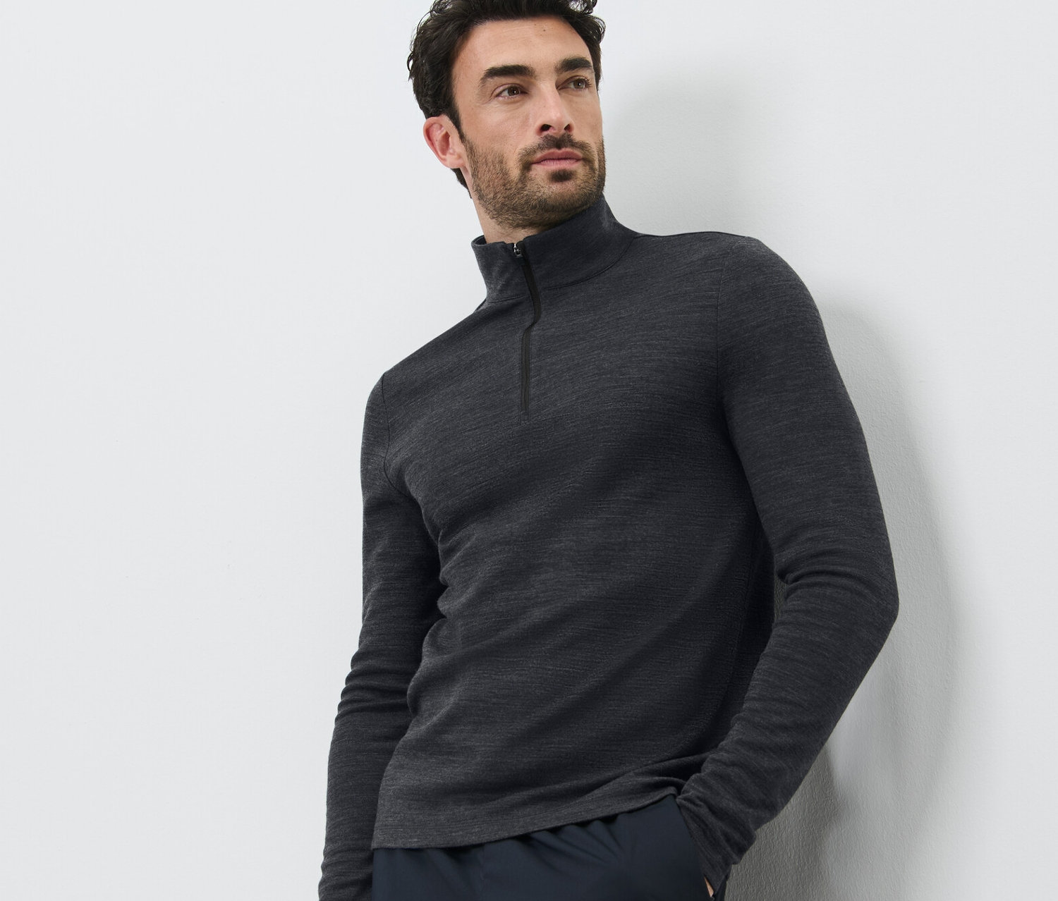 Muž pózuje na bielom pozadí a má na sebe funkčné tričko s vlnou certifikovanou podľa RWS a tmavé nohavice.