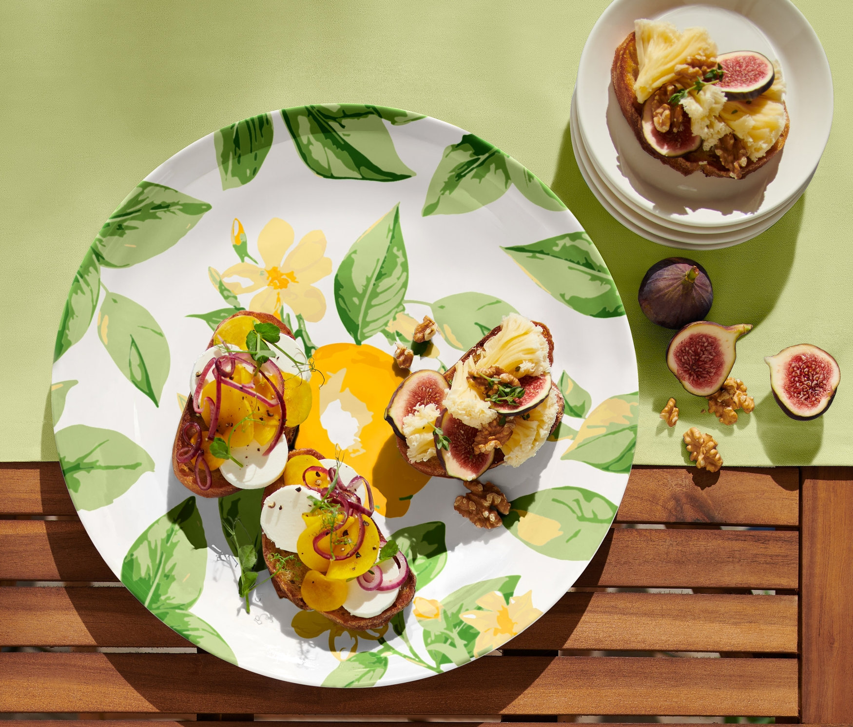 Na servírovacom tanieri sú tri toasty s figami a syrom. Na stole sú aj ďalšie figy a orechy.