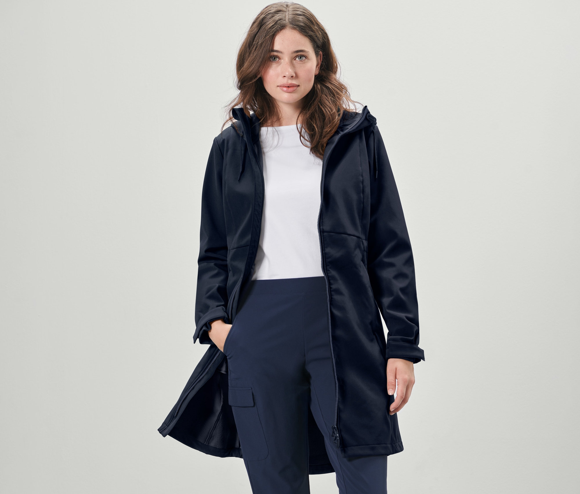 Žena má na sebe tmavomodrý softshellový kabát.