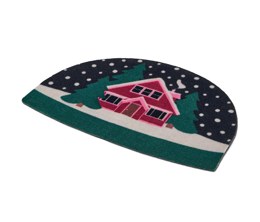 Rohožka s motívom zasneženého domu medzi stromami.