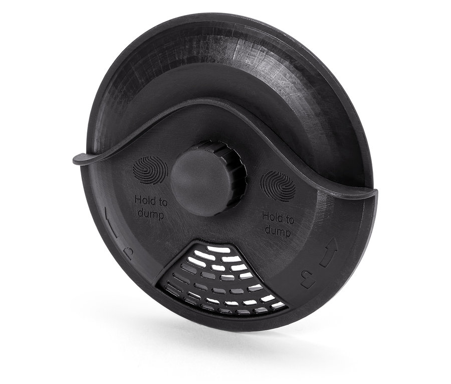 Detailný pohľad na čierny plastový kryt s nápisom "Hold to dump" a mriežkou.