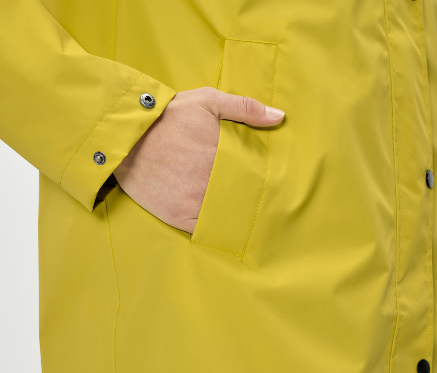 Ruka vo vrecku žltého kabáta.