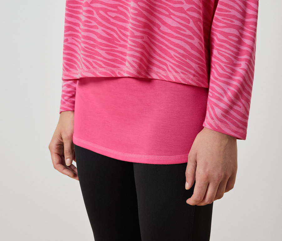 Detail ženskej postavy v ružovom tope so zvieracím vzorom a čiernych legínach.