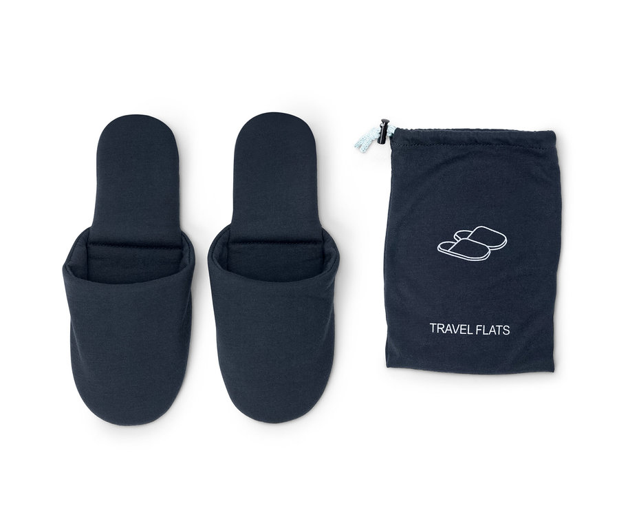 Dvoje modré cestovné domáce šľapky vedľa modrého puzdra.