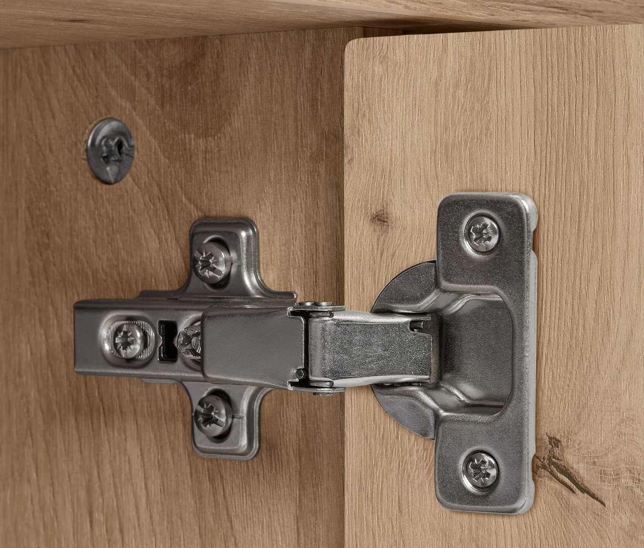 Detail strieborného pántu na drevenom REET sideboarde.