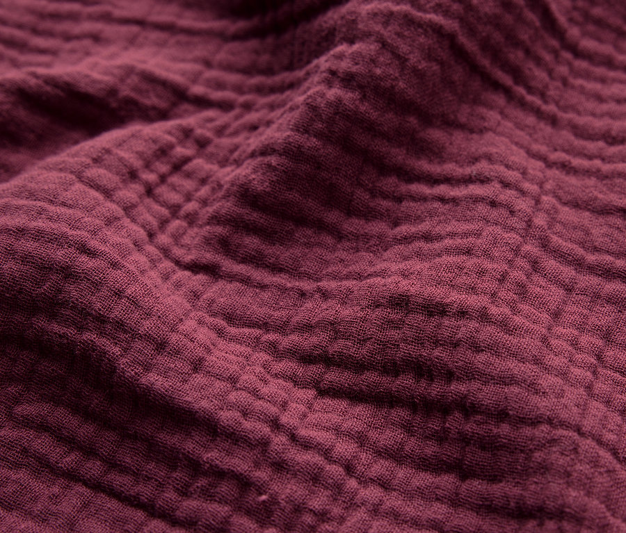 Detailný záber na textúru vínovočervenej látky.