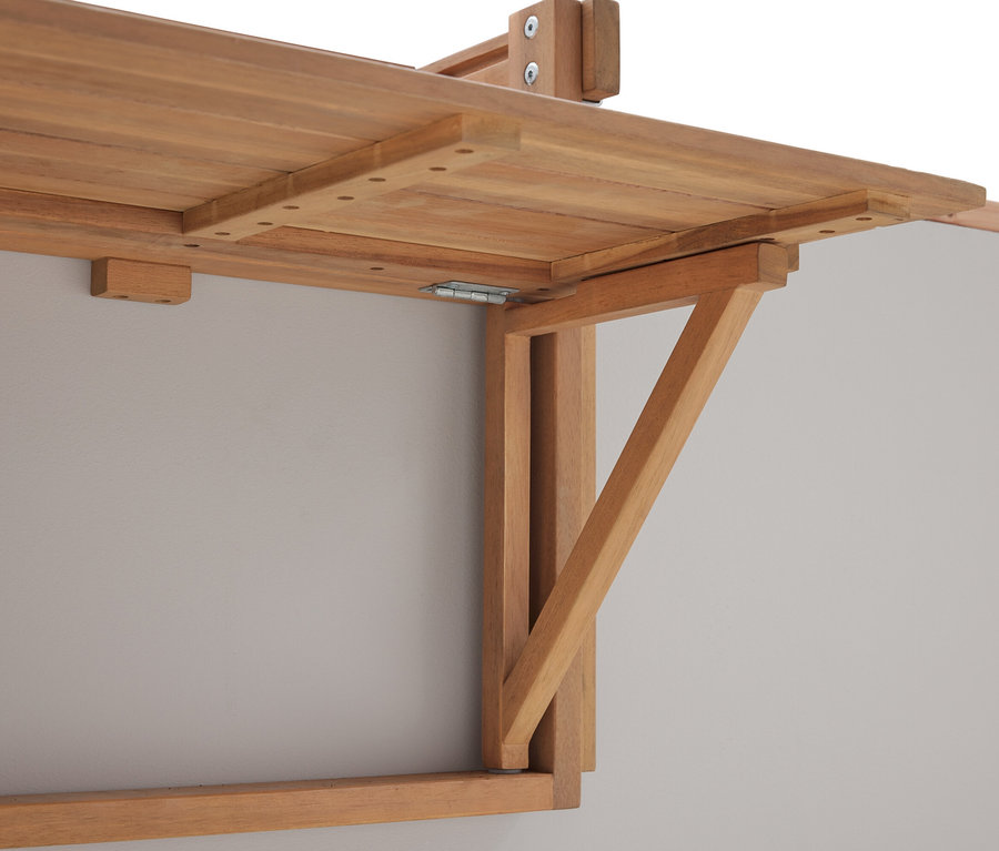 Detailný záber na sklopný drevený stôl namontovaný na sivej stene.