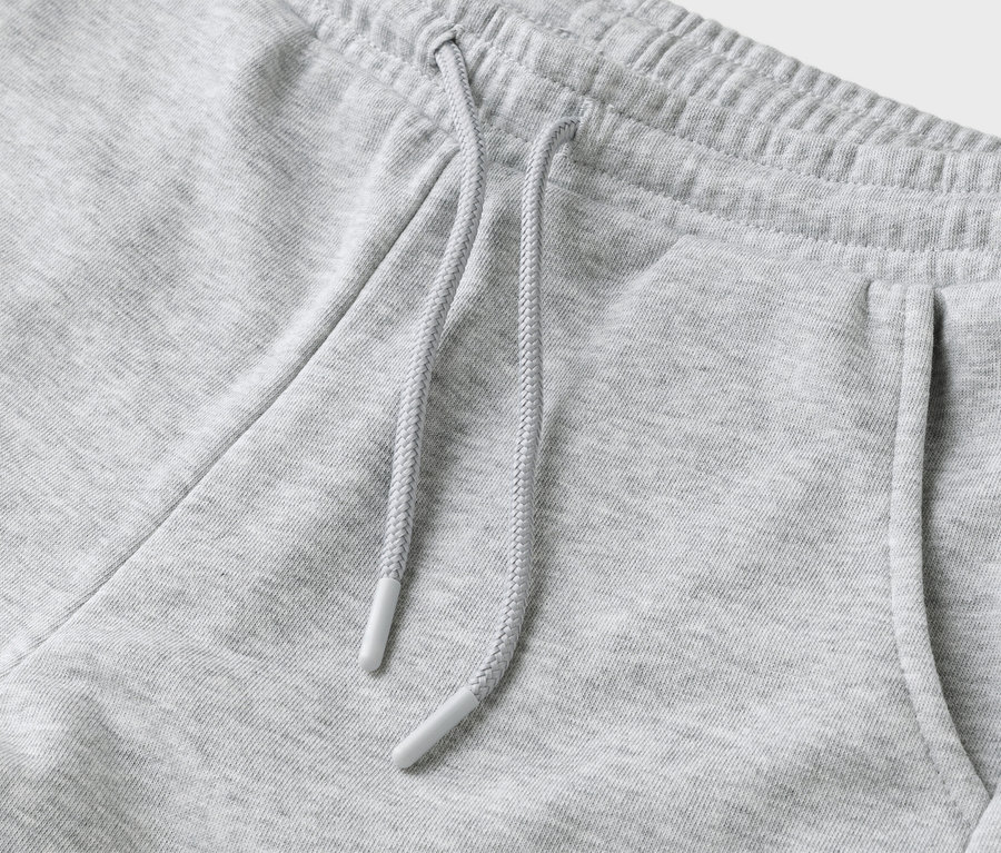 Detailný záber sivých teplákov so šnúrkou a vreckom.