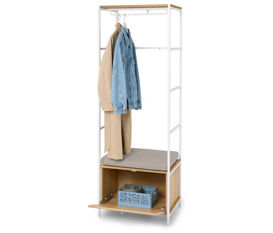 Vešiak s béžovou bundou, rifľovou bundou a béžovými nohavicami na vešiakoch, sivým sedadlom a modrým košíkom s oblečením.