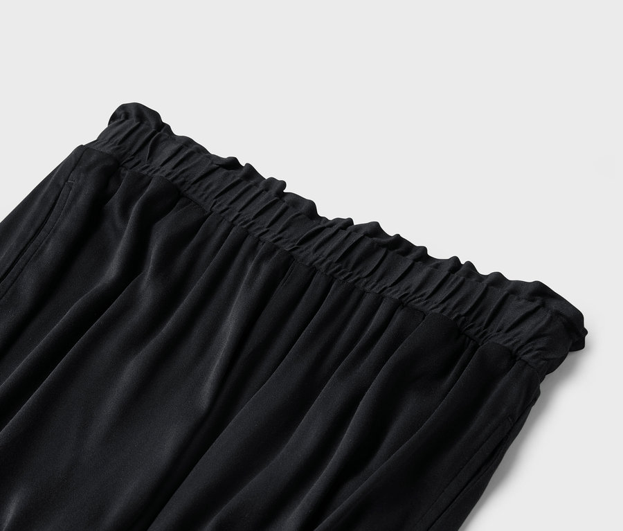 Detailný záber čiernych nohavíc s elastickým pásom.