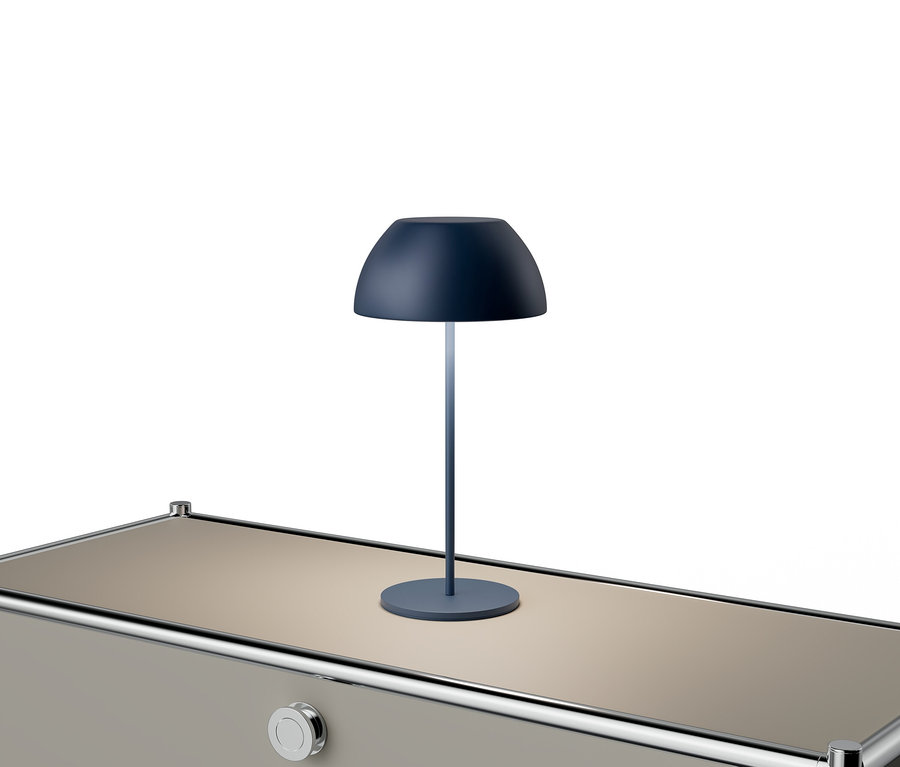 Modrá lampa stojí na béžovom stole so striebornými akcentmi.