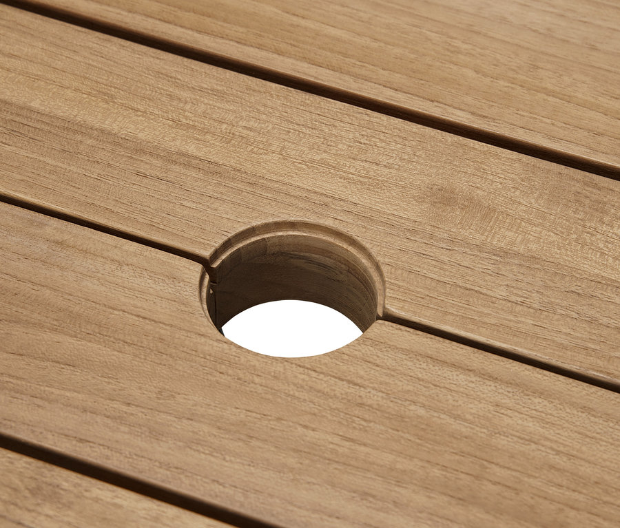 Detail prémiového záhradného stola z tíkového dreva s otvorom v strede.