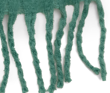 Detail zelenej tkanej šály s strapcami.