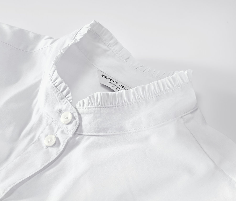 Detail bielej blúzky s nariaseným detailom.