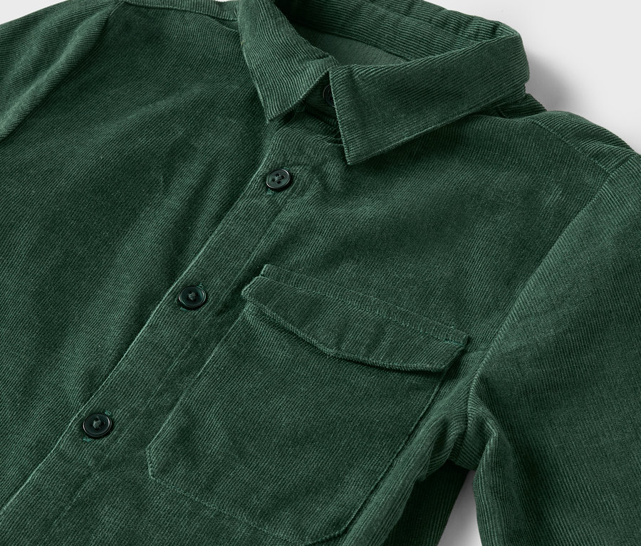 Detail zelenej menčestrovej košele s gombíkmi a náprsným vreckom.