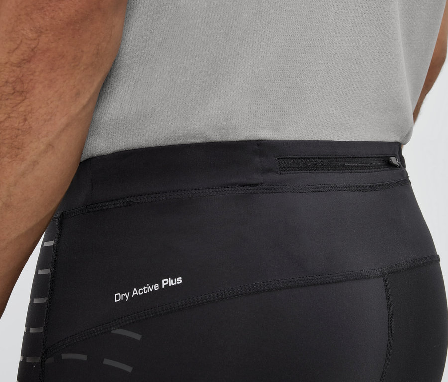 Muž má na sebe čierne legíny s nápisom Dry Active Plus a vreckom na zips v páse.