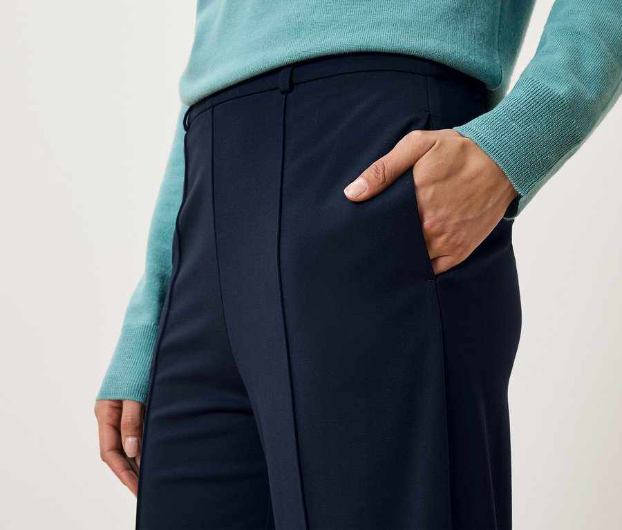 Detail dámskych nohavíc s rukou vo vrecku.