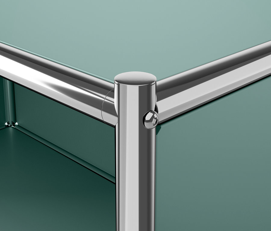 Detail rohu zeleného nábytku s chrómovanou nohou.