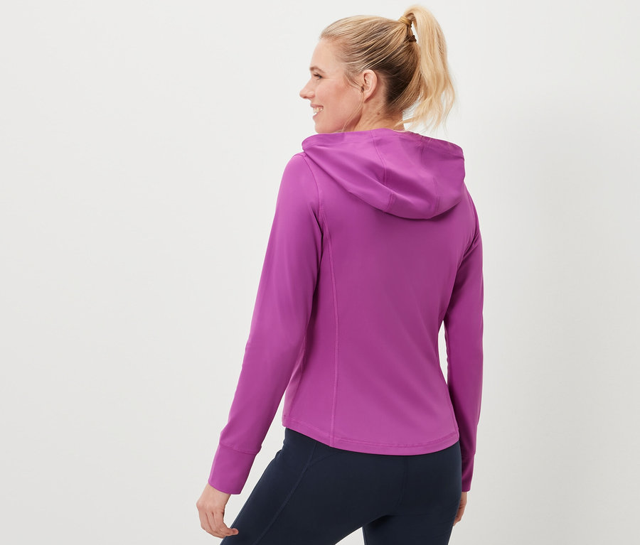 Žena má na sebe športovú bundu a tmavomodré legíny.