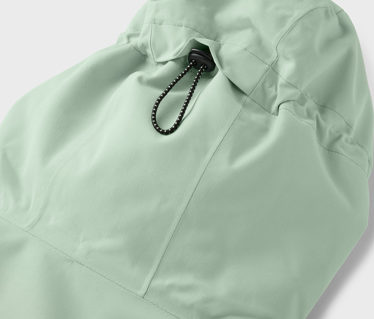 Detail kapucne svetlozelenej bundy so sťahovacou šnúrkou.