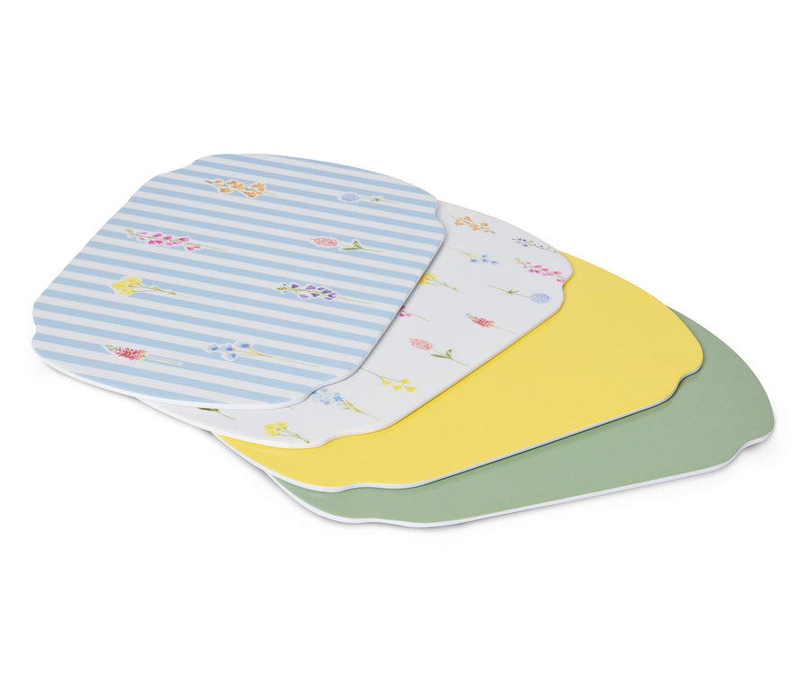 Niekoľko prestieraní leží na sebe, vrátane jedného modro-bieleho pruhovaného, jedného bieleho s kvetinovým vzorom, jedného žltého a jedného zeleného.