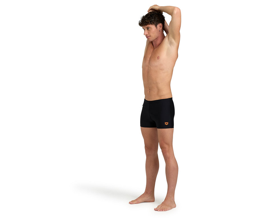 Muž sa naťahuje a má na sebe čierne plavky.